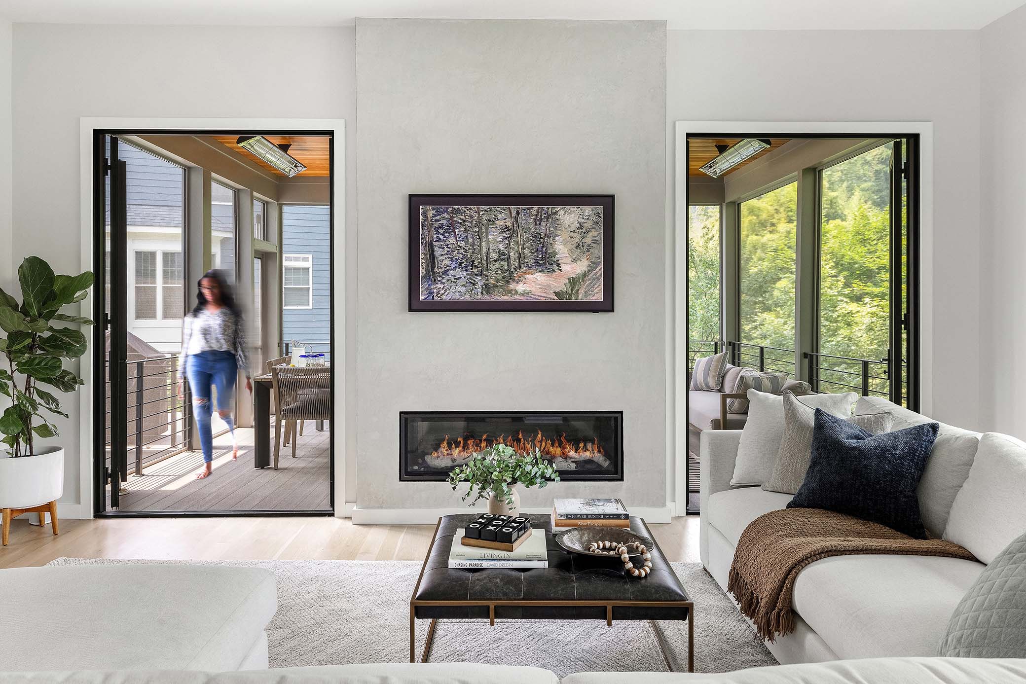 McLean VA interior design featuring modern plaster linear gas fireplace, frame art TV, and screened patio transitions captured by interior photographer