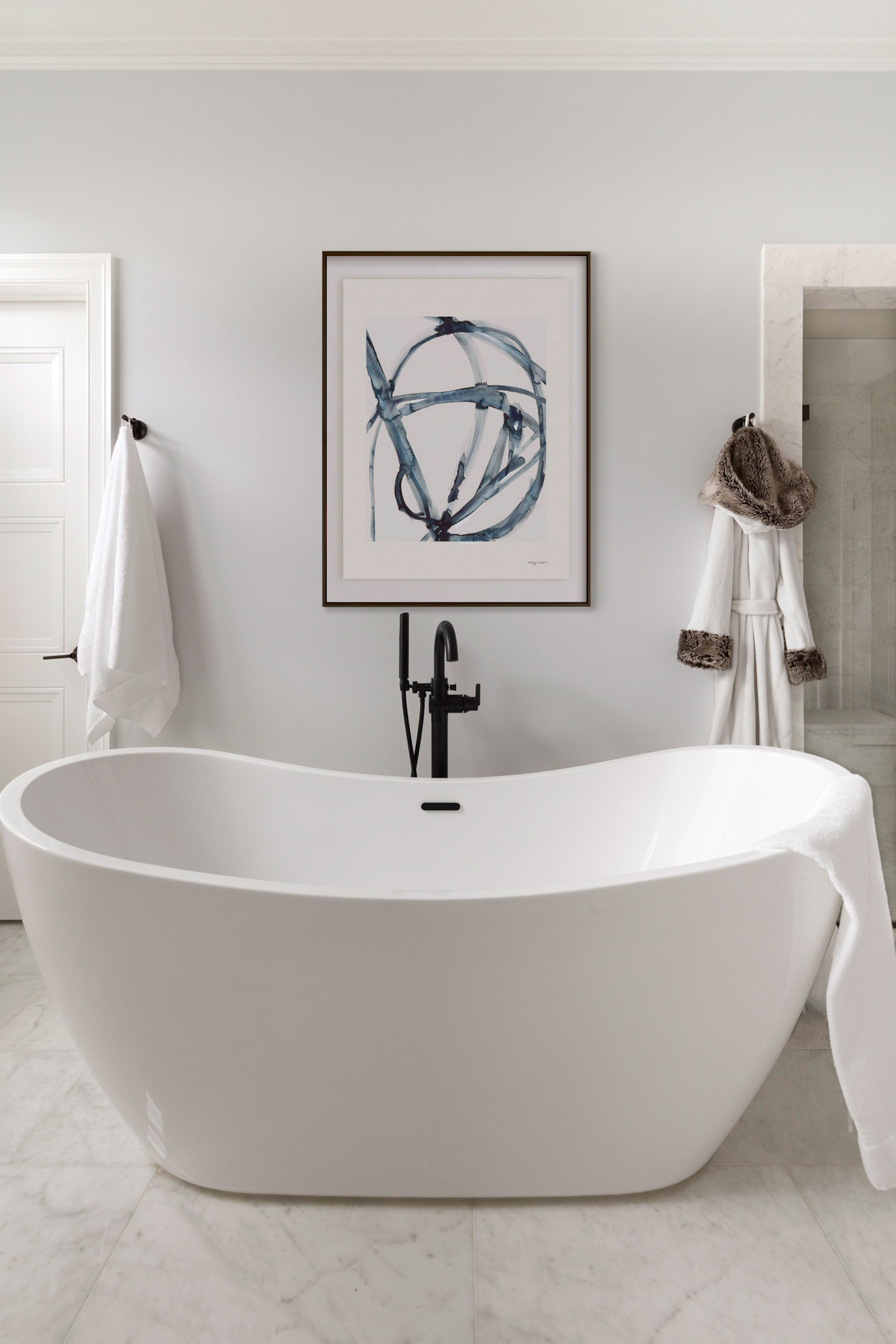 Luxury spa primary bathroom in Loudoun County Virginia featuring freestanding white soaking tub, matte black plumbing fixtures, and marble flooring captured by interior and architectural photographer