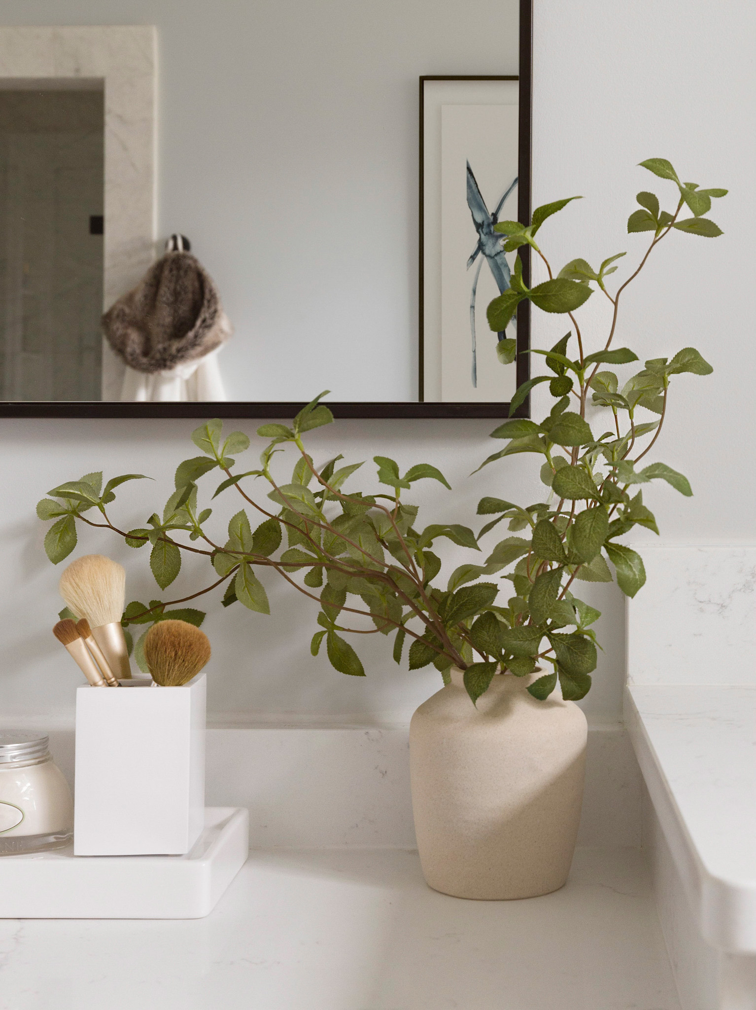 Bathroom vanity styling detail in Loudoun County Virginia with ceramic vase, natural greenery, and quartz countertop captured by interior and architectural photographer